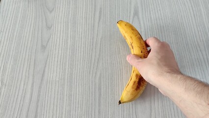 Man hand puts an apple and a banana on the table