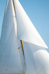 Fototapeta premium White Dacron sails on a classic wooden sail boat with wooden masts.