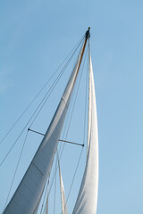 White Dacron sails on a classic wooden sail boat with wooden masts.