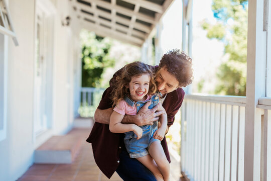 Father and daughter enjoying time together on a house porch