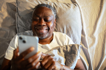 Senior man using smartphone at home