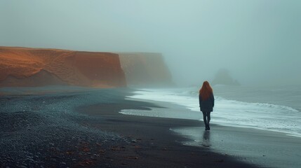 A girl walks along the beach in the distance