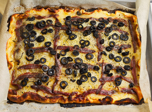 Baked pissaladi&egrave;re. Platter with this typical dish from the French Riviera. It consists of onion, black olives and anchovies on a dough. It is also known as French pizza