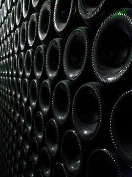 closeup image of wine bottles stacked in the cellar warehouse 