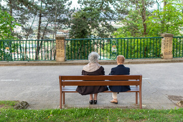 Retired women talking on a bench in the park