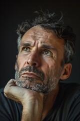 Obraz premium A portrait of a man with a thoughtful expression. His eyebrows are furrowed and his lips are pursed. He is thinking deeply and contemplating.