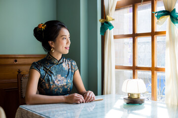 Woman wear traditional chinese cheongsam in the vintage restaurant