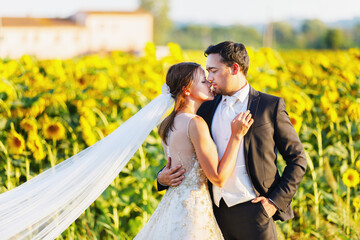 Beautiful bride and groom hugging and kissing on wedding day