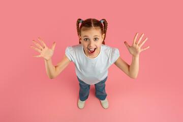 Excited girl with arms open on pink background