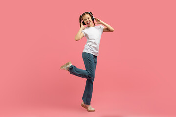 Fototapeta na wymiar Girl in headphones dancing with one leg up