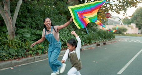 Family, flying a kite and girl with her mother outdoor together on the street for carefree or...