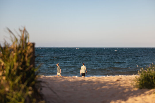 Brothers on the beach with sand pump. Teenage boys outdoors.