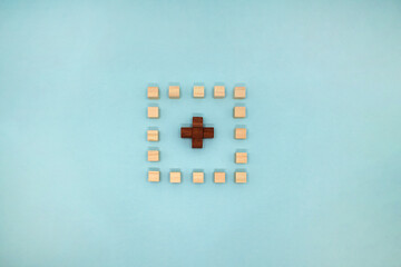 水色の背景の中心に十字のブロックを置いた四角いマーク