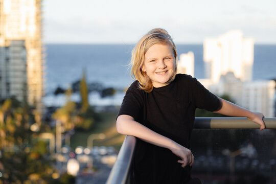 Pre-teen boy standing on balcony of high rise building on the Gold Coast with view