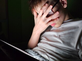 Shocked teenager guy watches prohibited content on social networks at night