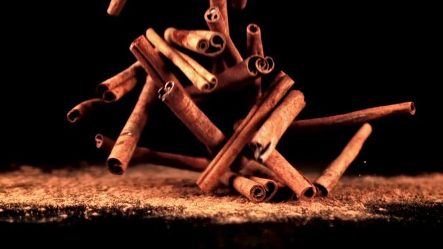Super slow motion in a pile on the table falling cinnamon sticks. High quality FullHD footage