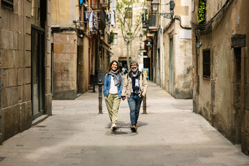 Senior tourist couple walking around Barcelona city enjoying summer vacation. Travel and holiday lifestyle concept.