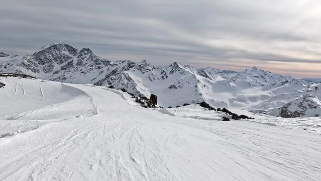 Skiing in mountains with stunning views of wild mountain range covered with fresh snow. Pov skier movement skiing down an empty slope at speed . Perfect winter outdoor activity sport. Slow motion, 4k