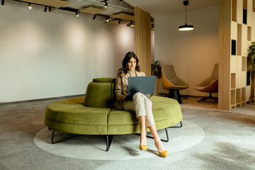 Sophisticated professional engrossed in her work at a modern cozy office lounge