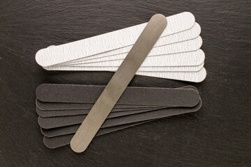 Manicure files with interchangeable files on slate stone, top view.