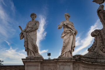 Classical marble statues under clear blue sky at the Vatican. Symbolism, intricate details,...