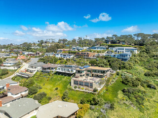 Aerial view of hillside luxury single family homes above Sunset Beach San Diego with palm trees and large terrace 
