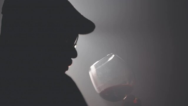 Sommeliers male with hat hold glass red wine tasting degustation card, Cinematic light scene with fog