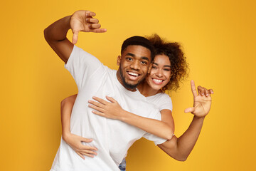 Couple having fun taking picture with imaginary camera