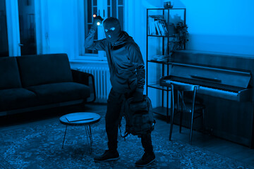 Person in hoodie exploring a blue-lit room