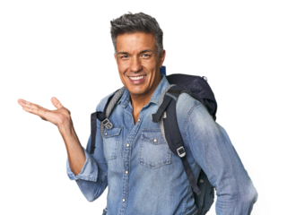 Hispanic hiker with backpack and flask showing a copy space on a palm and holding another hand on waist.