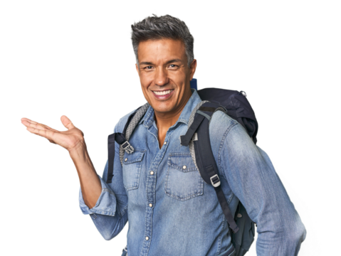 Hispanic hiker with backpack and flask showing a copy space on a palm and holding another hand on waist.