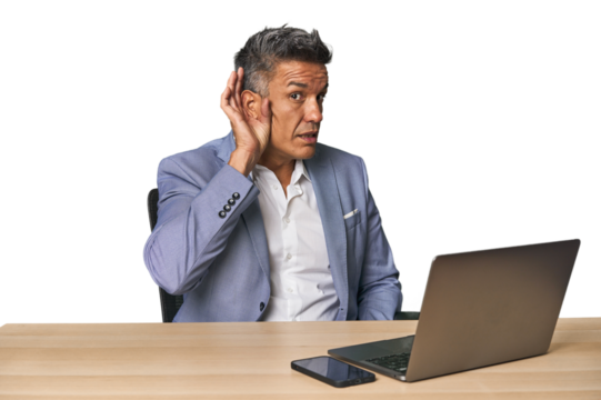 Elegant businessman at desk with laptop trying to listening a gossip.