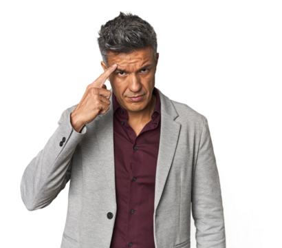 Middle-aged Latino man pointing temple with finger, thinking, focused on a task.