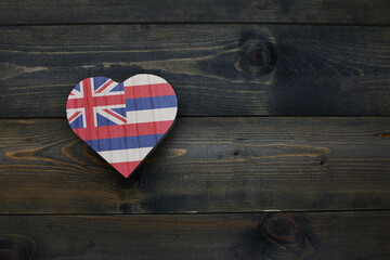 wooden heart with national flag of hawaii state on the wooden background.