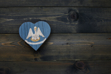 wooden heart with national flag of louisiana state on the wooden background.