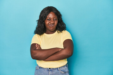 Young african american curvy woman frowning face in displeasure, keeps arms folded.