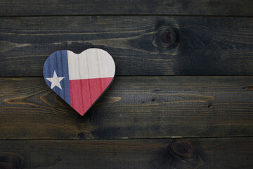 wooden heart with national flag of texas state on the wooden background.