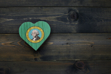 wooden heart with national flag of washington state on the wooden background.
