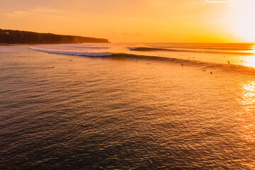 Drone view of best surfing waves at warm sunset. Perfect swell and surfers on wave in Bali - 779953727