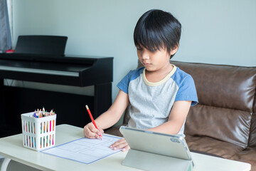 An Asian child boy doing his homework at home