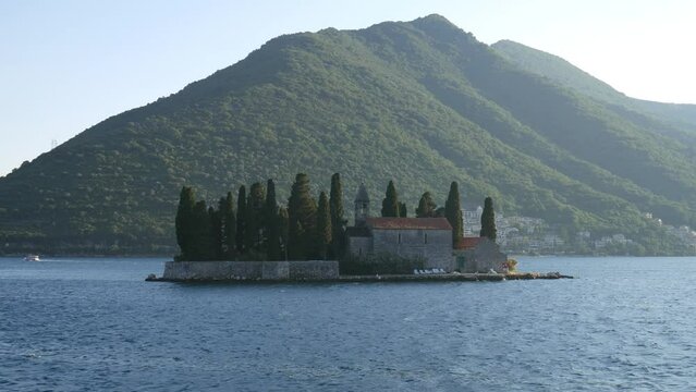 St.George Catholic monastery, Bay of Kotor, Montenegro, a view of a small island with an old building and a church. Shooting video from a moving boat.