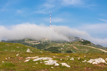 Hiking trail leading to mountain peak Dobratsch, Villacher Alps, Carinthia, Austria, Europe. Alpine meadow along the way to the radio tower on top. Panoramic view of hills and mountains. Wanderlust - obrazy, fototapety, plakaty