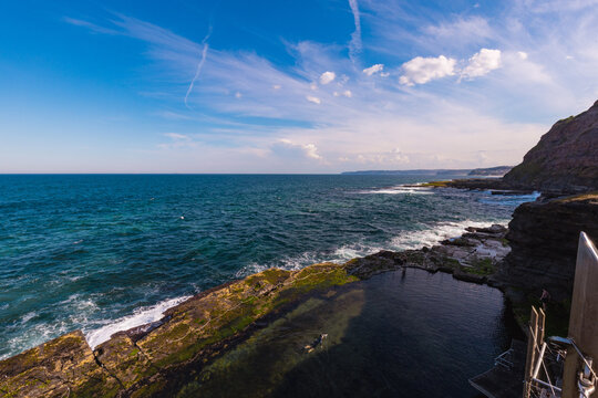 Man swimming in the Bogey Hole historic man made rock pool at Newcastle, NSW