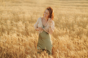 Joyful young female with a flower, feeling content in a vast wheat field at sunset, exuding peace and happiness.