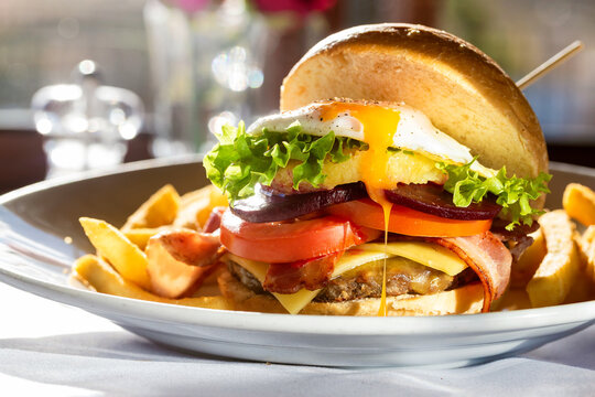 Plate with egg and meat burger with chips