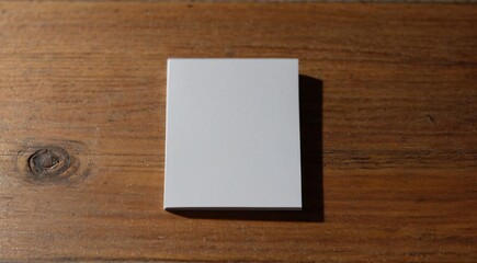 A blank white card resting on a wooden table.


