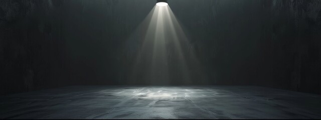 Obraz premium A stark black background with a bright spotlight illuminating an empty stage.