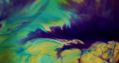 Glitter ink drip. Shiny liquid. Defocused purple blue yellow color sparkling golden sand particles...