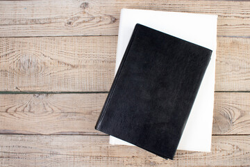 Black and white books on a wooden table. Top view. Copy Space.