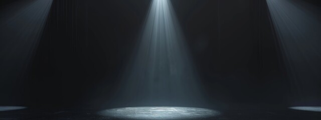 A stark black background with a bright spotlight illuminating an empty stage.